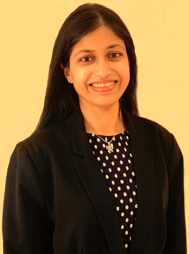 Photo of Vidya Nathan wearing a blue polka dot top with a black blazer.